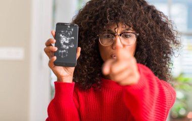 Tutan Afrikalı-Amerikalı kadın kamera ve size, parmak ile işaret smartphone kırık el işareti, pozitif ve kendinden emin bir jest ön