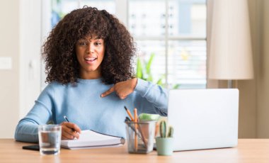 Afrikalı-Amerikalı kadın eğitim evde bilgisayar dizüstü için kendini parmakla sürpriz yüz ile kullanma