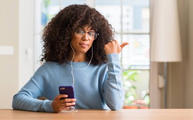 El ve parmak ile yukarı dönük mutlu yüz gülümseyen ile smartphone kullanarak güzel bir Afrikalı-Amerikalı kadın