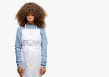 Uykulu ifade, çok çalıştırılıyordu ve yorgun ile bir önlük giyen Afro-Amerikan dükkanı sahibi kadın