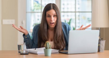 Evde çok mutlu ve heyecanlı, kazanan ifade büyük gülümseme ile çığlık ve ellerini kaldırdı zaferini kutluyor okuyan genç öğrenci kadın