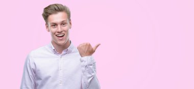 Genç yakışıklı sarışın adam el ve parmak ile yukarı dönük mutlu yüz gülümseyen ile