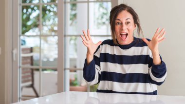 Orta yaşlı kadın çok mutlu ve heyecanlı, kocaman bir gülümseme ile çığlık ve ellerini kaldırdı kazanan ifade kutluyor zafer