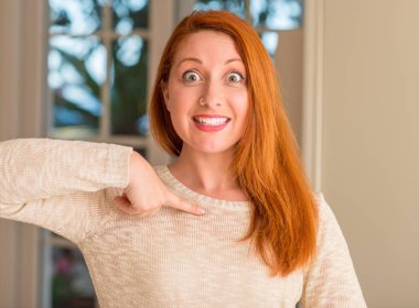 Kızıl saçlı kadın evde sürpriz yüz işaret parmağı kendisine