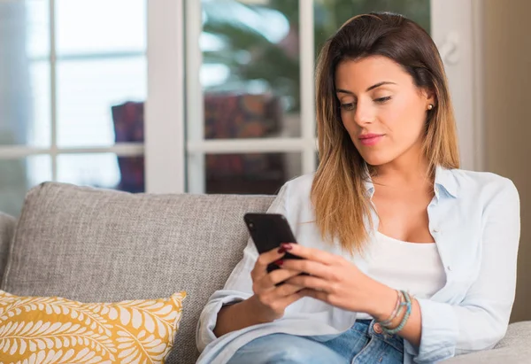 Jovem Mulher Bonita Falando Telefone Sofá Olhando Confiante — Fotografia de Stock