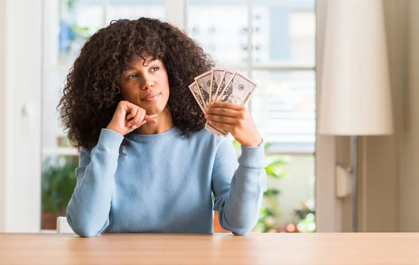 Mujer Afroamericana Sosteniendo Billetes Banco Dólares Cara Seria Pensando Pregunta — Foto de Stock