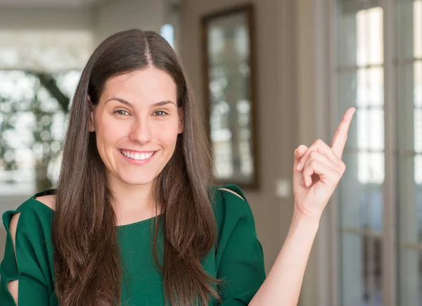 Ev çok mutlu el ve parmak ile tarafına işaret genç güzel kadın