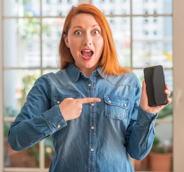 Donna Rossa Utilizzando Smartphone Casa Molto Felice Puntando Con Mano — Foto Stock