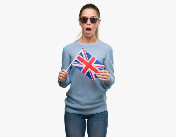 Όμορφη Νεαρή Γυναίκα Κρατώντας Σημαία Ηνωμένου Βασιλείου Φοβάται Σοκ Πρόσωπο — Φωτογραφία Αρχείου