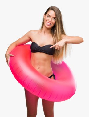 Güzel ve genç birbayan pembe tutan bikini float çok mutlu el ve parmak ile işaret