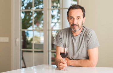 Bir kadeh şarap kendine güvenen bir ifade ile acımak yüz ciddi düşünüyorum içmek orta yaş erkek