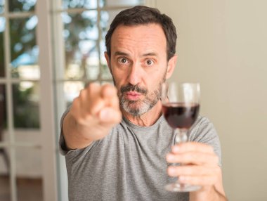 Orta yaş adamım şarap parmak ile işaret kamera ve size, el işareti, pozitif ve kendinden emin bir jest ön cam içme
