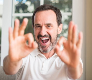 Parmak, mükemmel sembolü ile ok işareti yapan yakışıklı orta yaş erkek