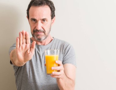 Komuta sizde açık eliyle dur işareti ile ciddi ve kendine güvenen ifade, savunma jest yapıyor bir bardak portakal suyu içme