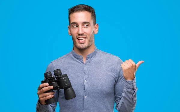 Joven Guapo Mirando Través Prismáticos Apuntando Con Mano Dedo Hacia — Foto de Stock