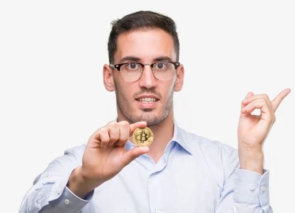 Guapo Joven Sosteniendo Bitcoin Muy Feliz Señalando Con Mano Dedo —  Fotos de Stock