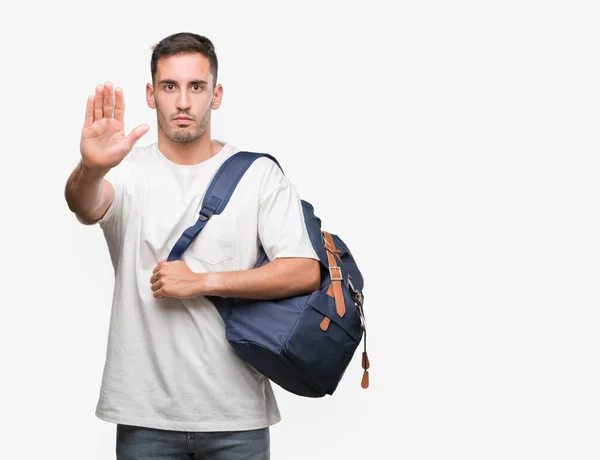 英俊的年轻人拿着背包用张开的手做停止标志以严肃和自信的表达 防御手势 — 图库照片