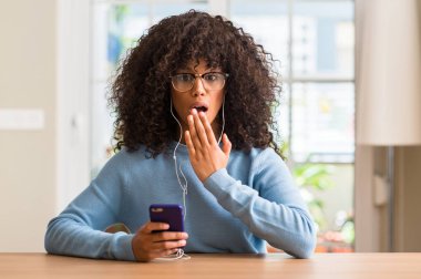 Hata için ifade korku, utanç ile şok el ile Smartphone kapak ağız kullanan güzel Afrikalı-Amerikalı kadın sessizce, gizli kavramı korkuttu