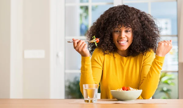 Africano Mulher Americana Comer Salada Macarrão Casa Gritando Orgulhoso Celebrando — Fotografia de Stock