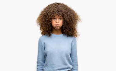 African american woman wearing a sweater puffing cheeks with funny face. Mouth inflated with air, crazy expression. clipart