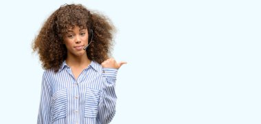 Afrikalı-Amerikalı çağrı merkezi operatörü kadın el ve mutlu yüz gülümseyen parmak ile işaret