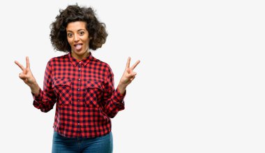 Güzel Arap kadın parmakları tong ve verme zafer işaretiyle gösterilen kamera bakıyor