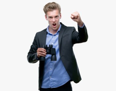 Genç yakışıklı sarışın adam öfkeyle, çılgın ve bağrışmalar yükseltilmiş el, öfke kavramı ile dürbün rahatsız ve hayal kırıklığına uğramış bağırarak üzerinden seyir