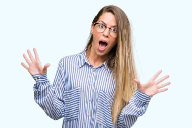 Güzel genç kadın şık gömlek ve çılgın ve silah ile başarı için hayran kutluyor gözlük kaldırdı ve açık gözleri çığlık heyecanlı. Kazanan kavramı