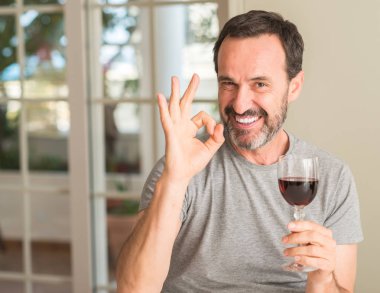 Parmak, mükemmel sembolü ile ok işareti yapıyor şarap içme orta yaş erkek