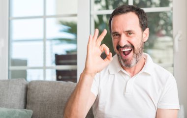 Parmak, mükemmel sembolü ile ok işareti yapan yakışıklı orta yaş erkek