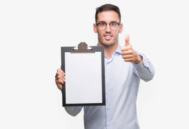 Yakışıklı genç iş adamı ok işareti, başparmak ile parmak, mükemmel işareti yapıyor kocaman bir gülümseme ile bir pano mutlu gösterilen