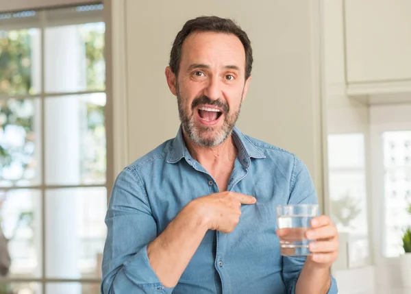 Hombre Mediana Edad Bebiendo Vaso Agua Con Cara Sorpresa Señalando —  Fotos de Stock