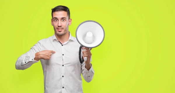 Bonito Jovem Segurando Microfone Com Rosto Surpresa Apontando Dedo Para — Fotografia de Stock