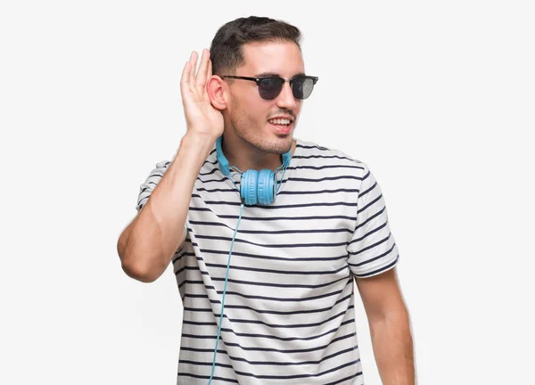 Pohledný Mladý Muž Nošení Sluchátek Úsměvem Rukou Přes Ucho Naslouchá — Stock fotografie