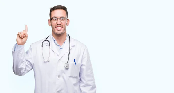 Guapo Joven Doctor Hombre Mostrando Señalando Hacia Arriba Con Dedo —  Fotos de Stock