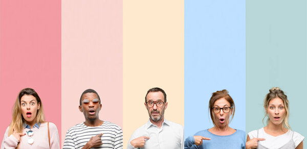 Смешанная группа людей, женщин и мужчин счастлива и удивлена приветствием, выражающим вау-жест, указывая пальцем
