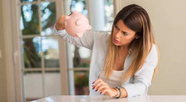 Güzel ve genç birbayan kumbara evde, ne kadar para var merak kırdı. İş kavramı.