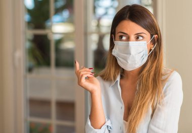 Güzel genç kadın evde kirlenme maske takıyor. Kirliliği ve hastalık kavramı.