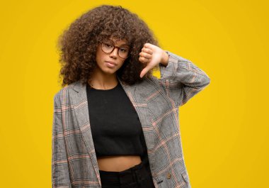 Kızgın yüz, eksi işareti aşağı antipati başparmak ile gösterilen, ret kavramı ile bir ceket giyen Afrikalı-Amerikalı kadın