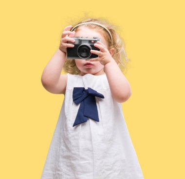Güzel sarışın yürümeye başlayan çocuk vintage fotoğraf makinesi ile fotoğraf çekmek