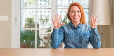 Kızıl saçlı kadın evde gösterilen ve parmak sekizinci ile gülümseyen ise kendinden emin ve mutlu yukarı dönük.