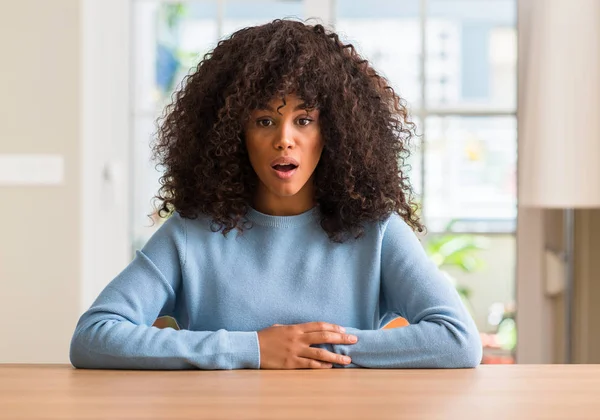 Afrikalı-Amerikalı kadın evde korkuyor ve sürpriz ifade ile şok korku ve yüz heyecanlı.