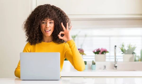非洲裔美国妇女使用计算机笔记本电脑在厨房做 标志与手指 优秀的标志 — 图库照片