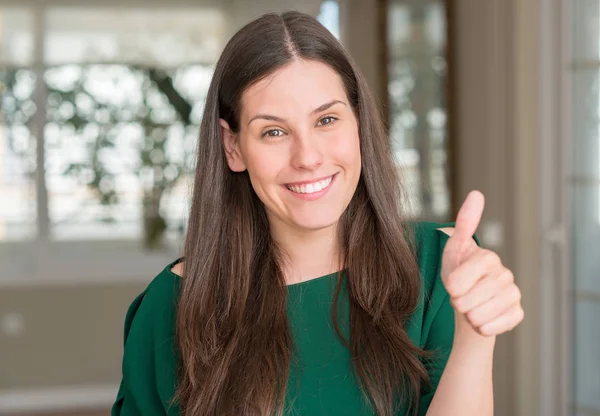 Genç güzel kadın ok işareti yapıyor büyük gülümseme ile mutlu ev, parmaklarıyla, mükemmel işaret parmak