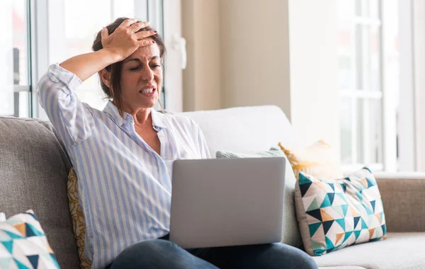 Middle Aged Woman Using Laptop Sofa Stressed Hand Head Shocked — Stock Photo, Image