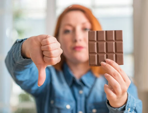 Mulher Ruiva Segurando Barra Chocolate Casa Com Rosto Irritado Sinal — Fotografia de Stock