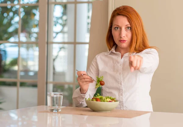 Rödhårig Kvinna Äta Färsk Grönsallad Hemma Pekar Med Fingret Till — Stockfoto