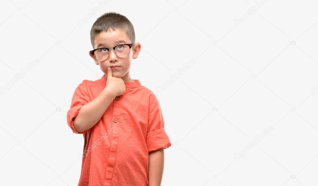 Dark haired little child wearing glasses serious face thinking about question, very confused idea