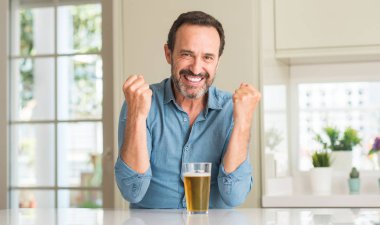 Duygu tezahürat gurur çığlık ve zafer ve başarı çok heyecanlı, kutluyor bira içme orta yaş erkek