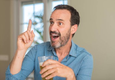 Orta yaş erkek bir fikirle sürpriz bira içmek ya da gülen yüz, bir numara ile işaret parmağı soru